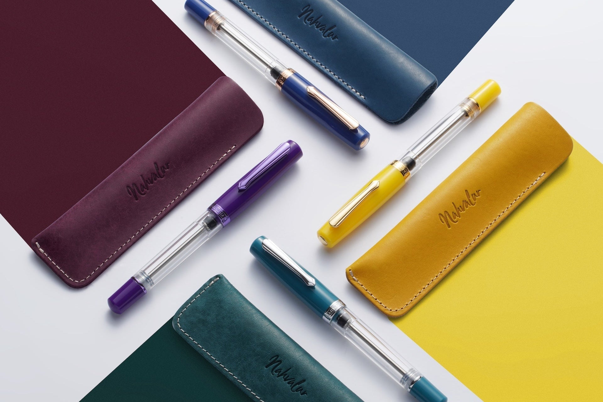 Colorful pens and leather cases on a white background